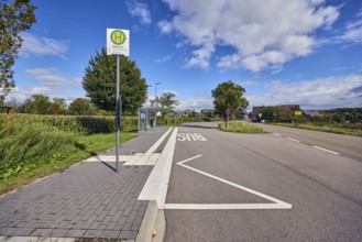 Hohnhurst bus stop, road marking BUS, town entrance, houses, corn field, trees, blue sky, cumulus