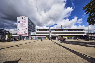 Train station, modern architecture, apartment building, concrete paving stone walkway, pedestrians