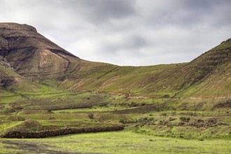 Green hills and rolling valley under a cloudy sky, Yaiza Lanzarote