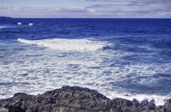 Open seascape with rocky shore and expansive horizon under blue sky, Playa del Janubio, Yaiza