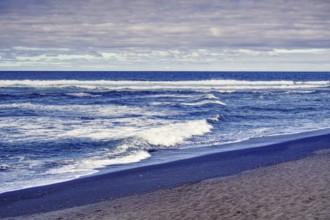 Coastline with wavy sea and sandy beach under cloudy sky, Playa del Janubio, Yaiza Lanzarote