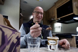 Man eats in the RV kitchen and smiles friendly, Middletown, USA