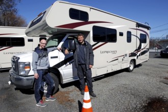 Two people smiling next to a parked motorhome, Middletown, USA