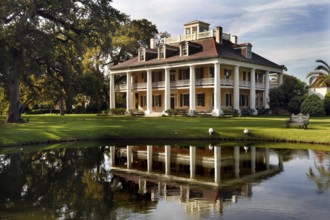 Elegant southern manor house with veranda and reflecting pond in a well-kept garden, zero