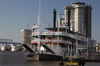 Paddle steamer against an urban backdrop on the riverbank, New Orleans, Louisiana, USA