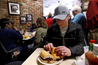 Lively restaurant interior, guests enjoy sandwiches in a relaxed atmosphere, New Orleans,