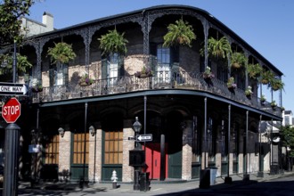 French Quarter corner building with decorated balconies and hanging plants, New Orleans, Louisiana,