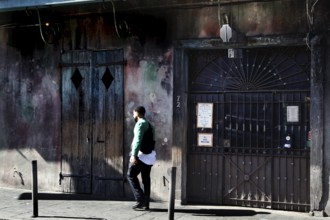 Ancient building with wall art and passing man, Preservation Hall, New Orleans, Louisiana, USA