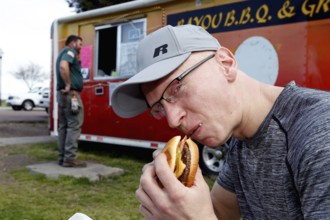 Man eating fast food in front of a food truck, Natchez, USA