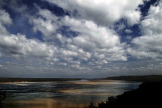 Wide river landscape with sandbanks under dramatic cloudy sky, Natchez, Mississippi, USA