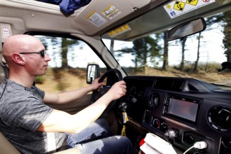 A man drives an RV on a tree-lined road, Natchez, Mississippi, USA