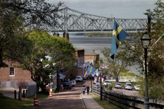 Street view in Natchez with bridge in background and flags along the road, Natchez, Mississippi,
