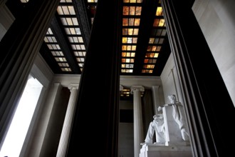 Monumental statue of Abraham Lincoln between tall pillars in a monumental building, Washington D.C,