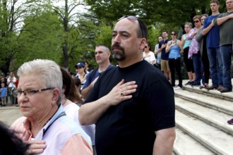 Crowds of people on stairs with hands on their hearts, expression of respect and patriotism,