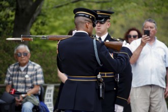 Two soldiers in parade uniform with rifle, spectators film ceremony, Washington D.C, USA