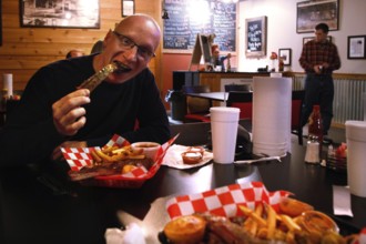 Person enjoying BBQ food in a cozy restaurant setting, Savannah, Georgia, USA