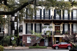 Historic townhouse with balconies and a red car in front of it in Savannah, Savannah, Georgia, USA