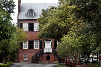 Brick house with Georgian architecture surrounded by trees and plants, Savannah, Georgia, USA