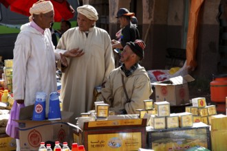Market scene with men talking in front of a variety of products, Msemrir, Region, MA