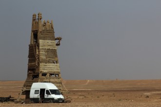 Desert scene with a tall rustic tower and a van in the foreground, Ouarzazate, Morocco