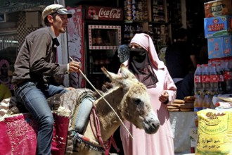 Market scene on Place Mohammed VI in Moulay Idris with a donkey and local inhabitants, Moulay