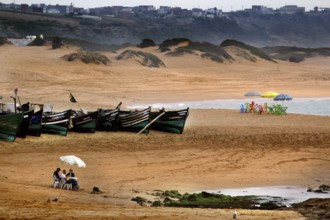 Expansive beach view with boats and people in Oulidia, Oulidia, Morocco