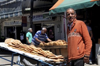 A bread seller presents his goods on the lively Place Mohammed VI in Moulay Idris, Moulay Idris,