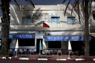 Blue and white café in Sidi Ifni with Moroccan flag and palm trees, Sidi Ifni, Souss-Massa, Morocco