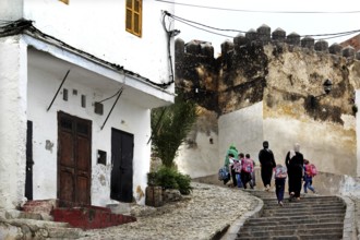People walk through historic Medina and climb a flight of stairs, Tangier, null, Morocco