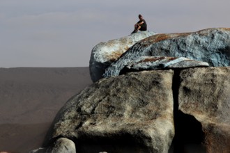 Person on the blue stones of artist Jean Verame with a wide view in Tafraoute, Tafraoute,