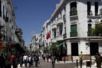 Bustling Avenue Mohammed V in Tetouan with white buildings and passers-by, Tetouan, Morocco