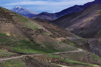 Barren mountain landscape with green valleys and a winding road in the High Atlas, Ouarzazate, High