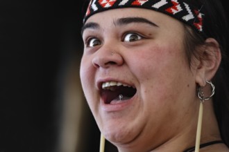 Woman with joyful facial expression in traditional dress, Rotorua, Whakarewarewa, New Zealand
