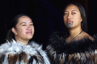 Two woman in traditional Maori garments pose for a portrait, Waitangi, New Zealand