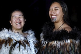 Two laughing woman in Maori robes radiate joy and community, Waitangi, New Zealand