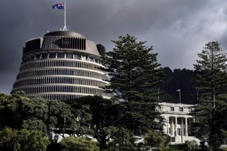 The parliament building 'Beehive' in Wellington surrounded by trees under a cloudy sky, Wellington,