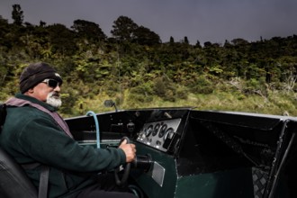 Man rides a motor boat along the Whanganui River through green nature, Whanganui River,