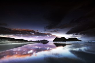 Dramatic sunset on Wharariki Beach with impressive reflection in the water, Wharariki, Tasman, New