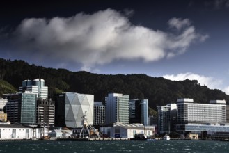 Modern building front on Wellington Waterfront under dramatically cloudy sky, Wellington, New