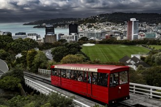 Red cable car overlooks Wellington and its green hills as well as the city, Wellington, New Zealand