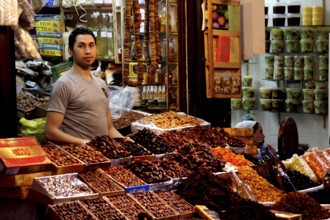 A retailer offers a variety of dried fruits at a busy market, Fez, Fez el Bali, Morocco