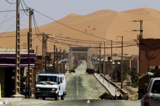 City scene near Merzouga with sand dunes in the background, Merzouga, Morocco