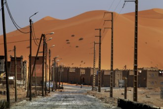 Dunes on the horizon behind the modern settlement of Merzouga, Merzouga, Niger, Morocco