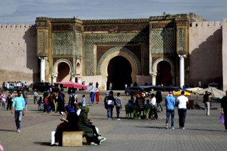 Large decorated gate in a public square, with people gathering, Meknes, Fès-Meknes, Morocco