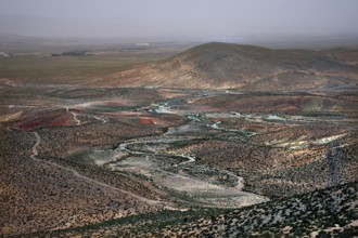 Wide, dry landscape with rolling hills and meandering river, Midelt, Morocco