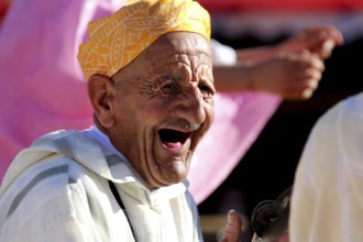 An elderly man laughs heartily during the traditional Berber festival, Ma El Kelâa m'Gouna, Fête