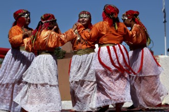 Women in traditional Berber garments dance during a festival, El Kelâa m'Gouna
