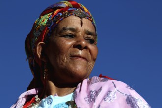 Woman wearing colorful traditional clothing and headdress at the Rose Festival in El Kelâa m'Gouna,