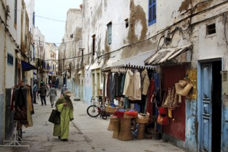 Shopping street with traditional shops and clothing displays in the old town, Essaouira,