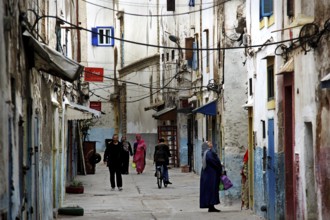 People stroll through a narrow alley within the historic old town, Essaouira, Marrakesh-Safi,
